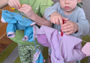 Asia i Julianka wieszają ubranka na sznurku.