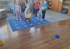 Dzieci rywalizują ze sobą ustawione w dwóch rzędach.