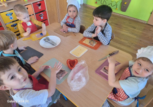 Dzieci przygotowują wielkanocną sałatkę z szynki i sera, wykrawają kształty zwierzątek z wykorzystaniem foremek do ciastek.