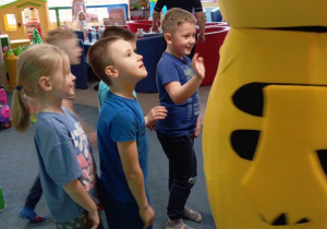 Dzieci "przybijają piątkę" z żywą maskotką Pikachu