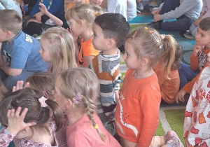 Dzieci siedzą na widowni podczas koncertu.