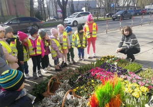 Pani opowiada dzieciom o wiosennych kwiatach.