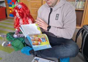 Tata Michasi czyta dzieciom bajki.