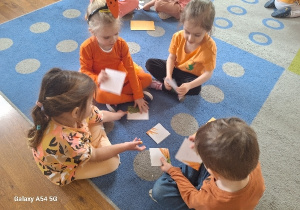 Dzieci układają "marchewkowe puzzle" w zespołach.