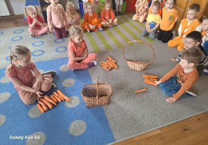 Dzieci przeliczają marchewki zebrane podczas konkursu.