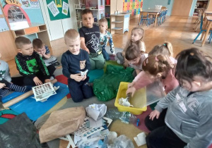 Dzieci segregują zgromadzone śmieci do określonych worków