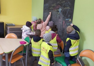 Dzieci rysują kredą na tablicy