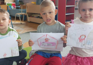 Dzieci prezentują ilustracje do bajki narysowane przez siebie