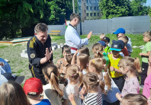 Dzieci "przybijają piątkę" z trenerem i jego asystentami