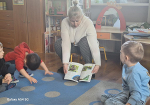 P. Bibliotekarka pokazuje dzieciom książeczki różnego typu.