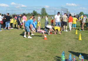 Dzieci wraz z członkami rodzin wykonują zadanie sportowe