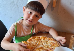 Wiktor zjada samodzielnie przygotowaną pizzę.