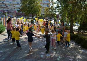 Dzieci wraz z Paniami bawią się na przedszkolnym dziedzińcu