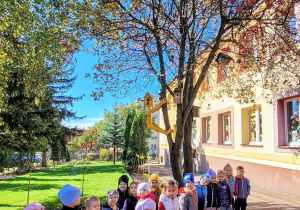 Dzieci stoją pod jarząbem.